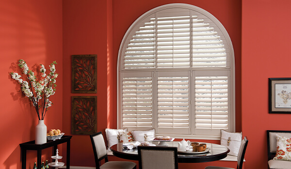 Shaped PVC shutters in red walled dining room