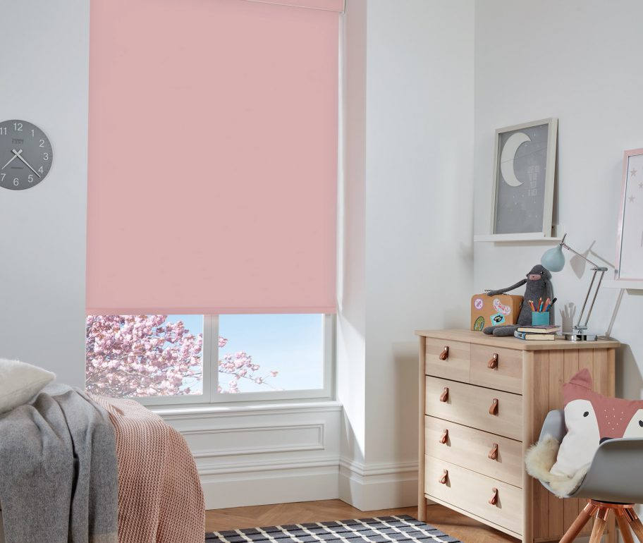 pastel pink blackout roller blinds in a bedroom