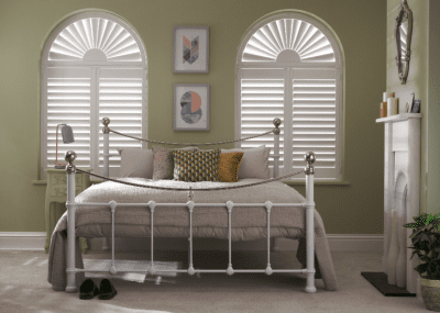 Arched window shutters in a bedroom