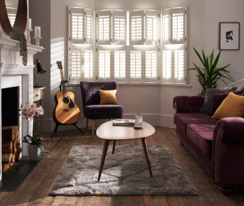 White wooden tier on tier shutters in living room bay window