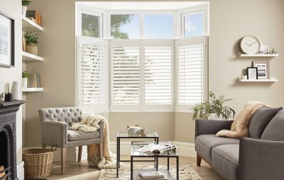 White cafe style shutters in living room bay window