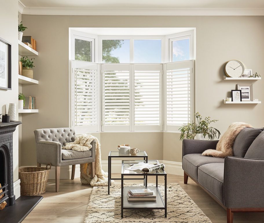 White cafe style shutters in living room bay window