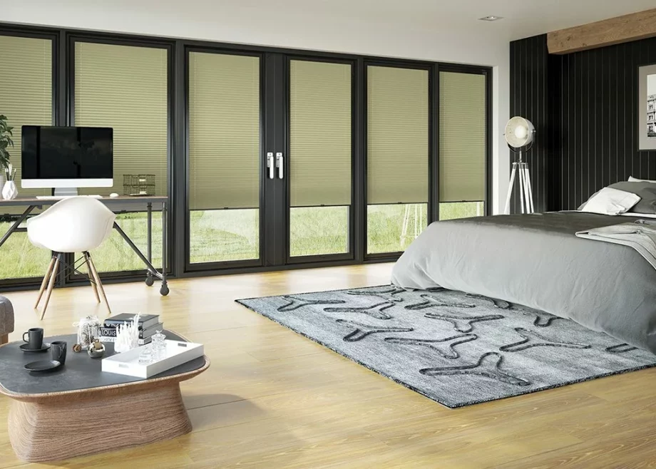 A bedroom with perfect fit duette blinds on the patio doors and windows